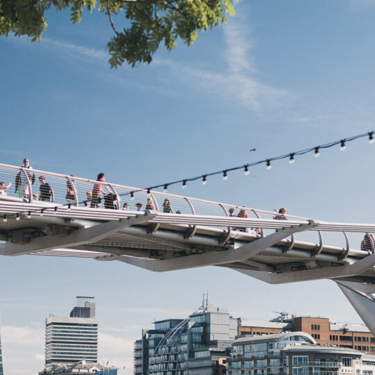 people walking over a bridge to show IX Bridge