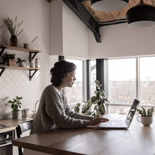 women sitting at a kitchen table working on a laptop, Remote working