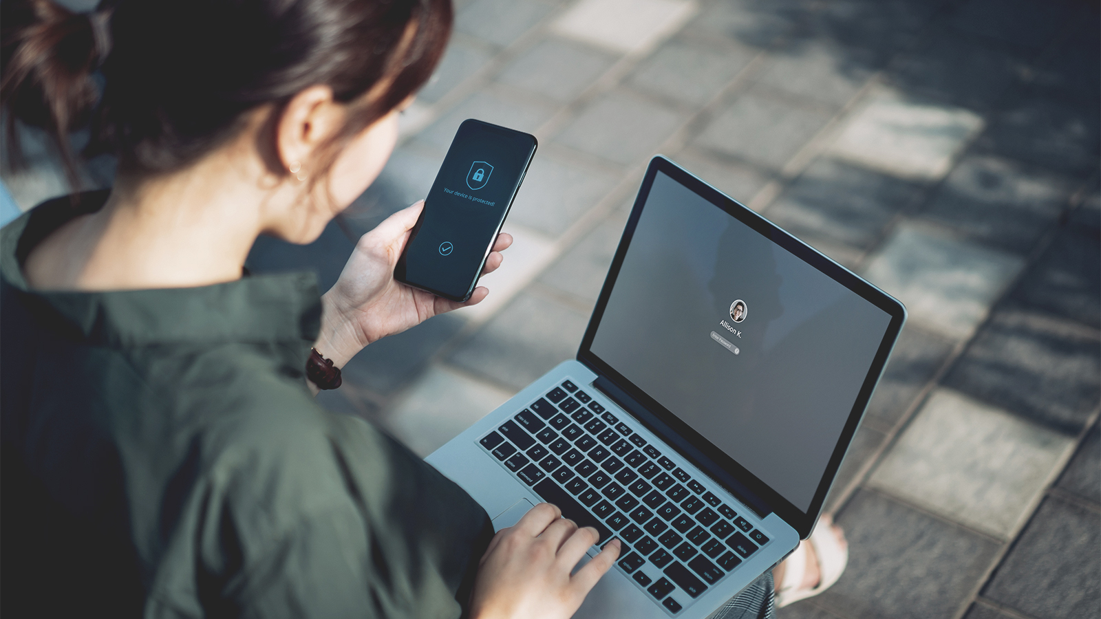 Women on her computer while looking at her phone Addressability Portfolio