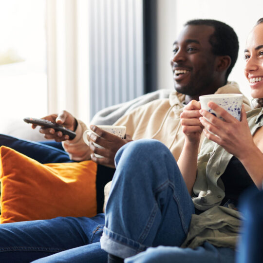 two people sitting on a couch watch CTV