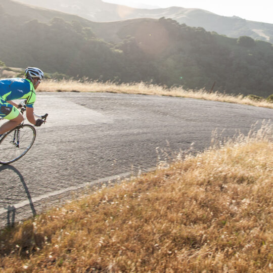 Cyclist in the mountains heading down a hill