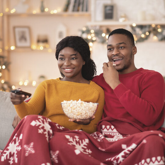 Two people watching CTV surrounded by holiday decorations