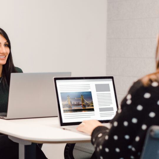 people sitting at a desk with their laptop