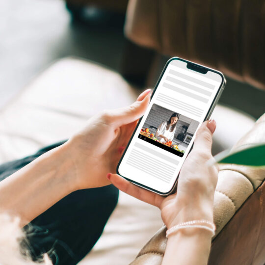 Femme regardant une vidéo outstream sur son téléphone