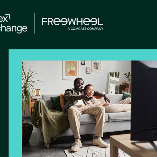 FreeWheelのロゴ、ソファでテレビを見る人々