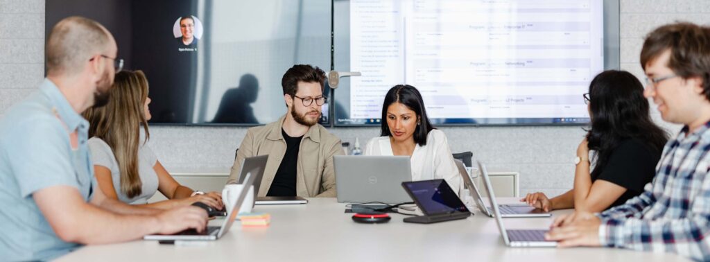 Employees working together with laptops in a conference room