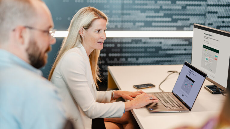 Colleagues working around a laptop