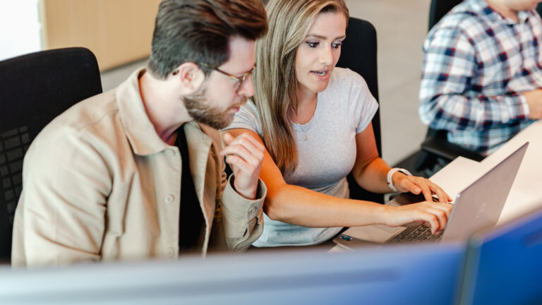 Co-workers looking at a laptop