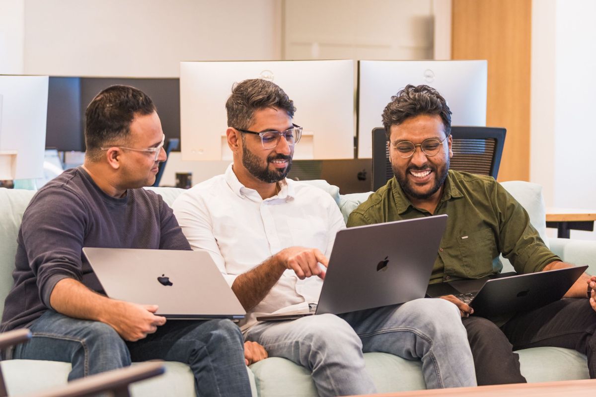 Three Index employees collaborating on laptops