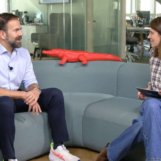 two people sitting on the sofa in the office chatting