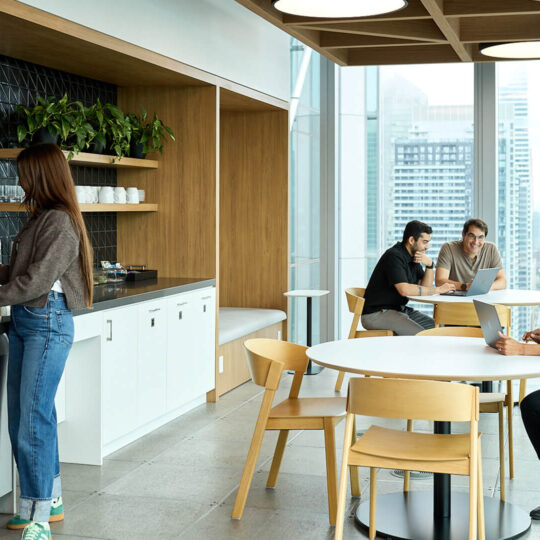 Picture of employees standing and sitting in the office break room