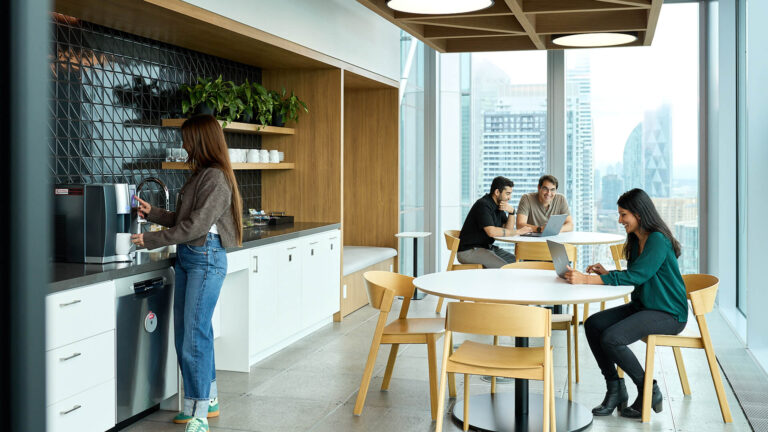 Picture of employees standing and sitting in the office break room